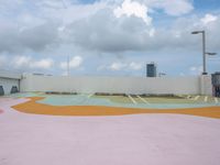 a roof with an open air park with a colorful mural on the pavement below some building