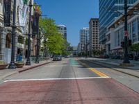 the green paint is painted on a bike path in front of an office building and large, trees