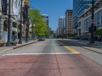 the green paint is painted on a bike path in front of an office building and large, trees