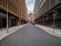 a long narrow road in the city with no traffic on it's sides, lined with buildings and street signs