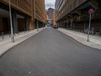 a long narrow road in the city with no traffic on it's sides, lined with buildings and street signs