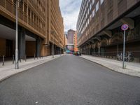 a long narrow road in the city with no traffic on it's sides, lined with buildings and street signs