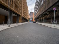 a long narrow road in the city with no traffic on it's sides, lined with buildings and street signs