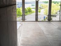 a person standing in an empty building while a skateboarder rides by them and their bike is seen