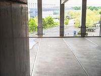 a person standing in an empty building while a skateboarder rides by them and their bike is seen