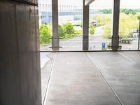 a person standing in an empty building while a skateboarder rides by them and their bike is seen