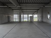 empty industrial space with grey metal flooring and open areas in front of the camera