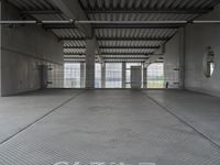 empty industrial space with grey metal flooring and open areas in front of the camera