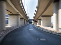 a blurry photo of two highway tracks and the center of a street with cars and traffic