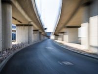 a blurry photo of two highway tracks and the center of a street with cars and traffic