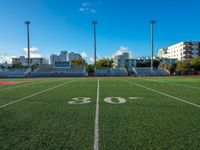 the soccer field that looks like a stadium with buildings in the background and the numbers 50