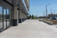 concrete sidewalk in the middle of city with vehicles parked nearby on the side walk on a sunny day