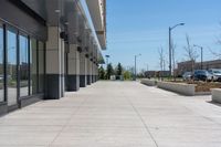 concrete sidewalk in the middle of city with vehicles parked nearby on the side walk on a sunny day