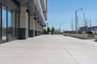 concrete sidewalk in the middle of city with vehicles parked nearby on the side walk on a sunny day