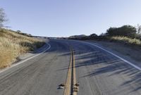 a long road is empty and there are no cars on it in the middle of the road