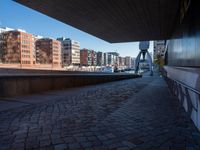 the walkway is made from brick bricks in this view of tall buildings and a waterway