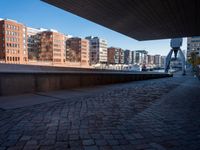 the walkway is made from brick bricks in this view of tall buildings and a waterway