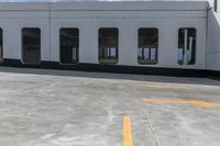 a yellow painted line of parking spaces on top of a building with doors and windows