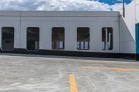 a yellow painted line of parking spaces on top of a building with doors and windows