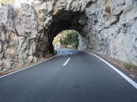 an image of the road going through a tunnel on top of mountains in italy on a clear day