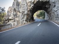 an image of the road going through a tunnel on top of mountains in italy on a clear day