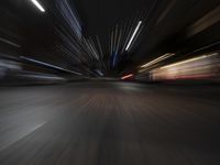 a car driving on a city street at night time, in motion with its headlights on