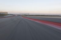 a curve of pavement with the lines painted red and white, as seen from a moving speedboat