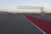 a curve of pavement with the lines painted red and white, as seen from a moving speedboat