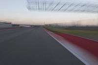 a curve of pavement with the lines painted red and white, as seen from a moving speedboat