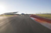 the camera is blurred from a car passing by the track and the other cars are in the background