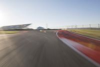 the camera is blurred from a car passing by the track and the other cars are in the background