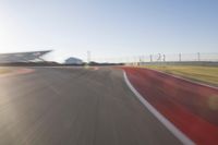 the camera is blurred from a car passing by the track and the other cars are in the background