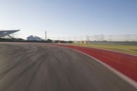 the camera is blurred from a car passing by the track and the other cars are in the background