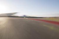 the camera is blurred from a car passing by the track and the other cars are in the background