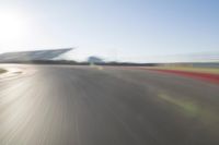 the camera is blurred from a car passing by the track and the other cars are in the background