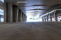 a large empty room with concrete floors and a ceiling covered by many metal poles and beams