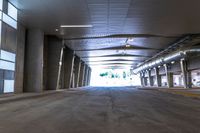 a large empty room with concrete floors and a ceiling covered by many metal poles and beams