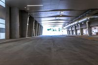 a large empty room with concrete floors and a ceiling covered by many metal poles and beams