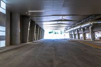 a large empty room with concrete floors and a ceiling covered by many metal poles and beams