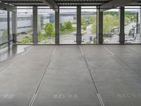 a view of an outdoor courtyard in a building with a lot of tall windows on one side and a street below