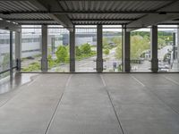 a view of an outdoor courtyard in a building with a lot of tall windows on one side and a street below