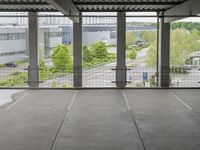 a view of an outdoor courtyard in a building with a lot of tall windows on one side and a street below