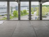 a view of an outdoor courtyard in a building with a lot of tall windows on one side and a street below