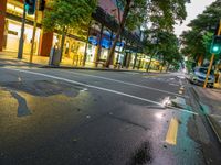 the intersection has red bricks and blue signs on the curb in front of store fronts