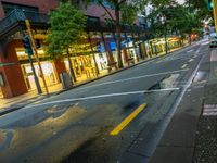 the intersection has red bricks and blue signs on the curb in front of store fronts