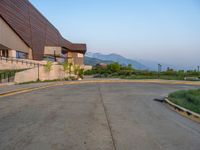 a building that has a bunch of windows on it at sunset with mountains in the background