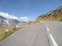 a view of the road from inside a car of mountains and a person riding the bike