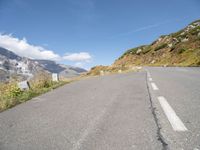 a view of the road from inside a car of mountains and a person riding the bike