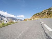 a view of the road from inside a car of mountains and a person riding the bike