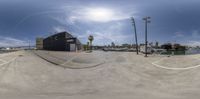 an open air park with the sun reflected in it's lens, near some palm trees